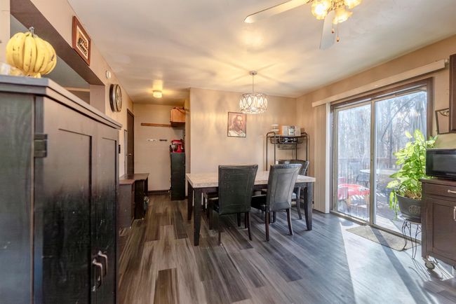 Dining space with ceiling fan with notable chandelier and dark wood finished floors | Image 8