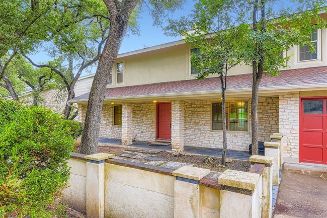 View of front facade featuring covered porch, a shingled roof, stucco siding, and stone siding | Image 4