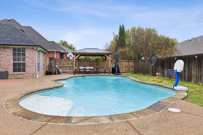 View of pool featuring a fenced backyard, a gazebo, a patio area, and a fenced in pool | Image 4