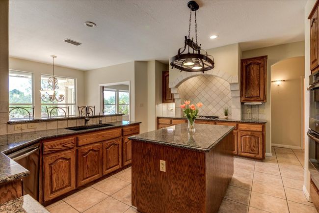 The kitchen island is a must-have for the avid cook or entertainer. The arched cooktop adds another layer of lovely. | Image 8