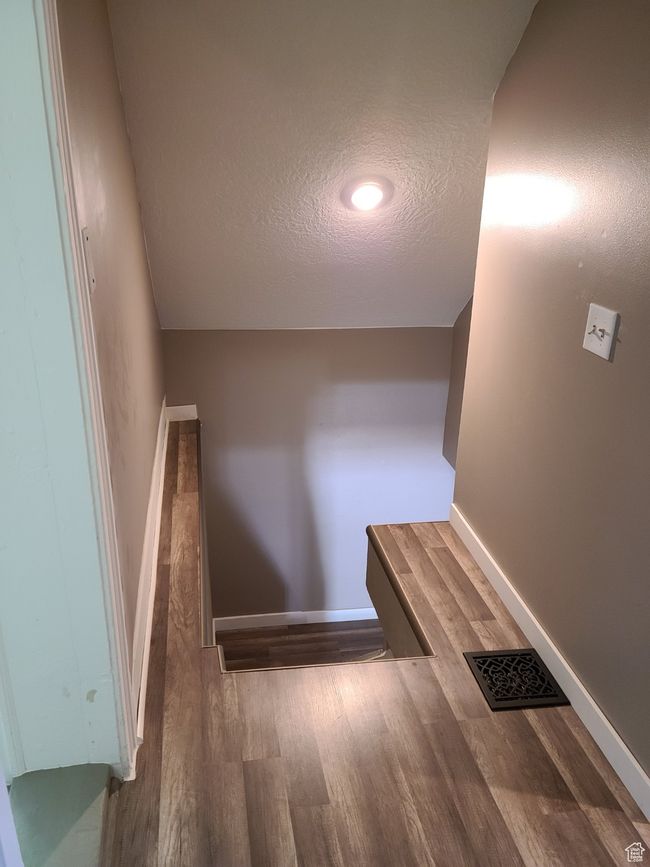 Stairs with wood finished floors, a textured ceiling, and baseboards | Image 21