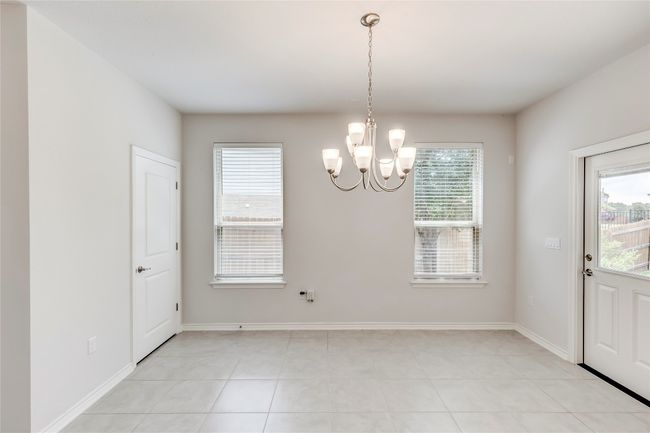 Unfurnished dining area with a chandelier, light tile patterned floors, and baseboards | Image 14