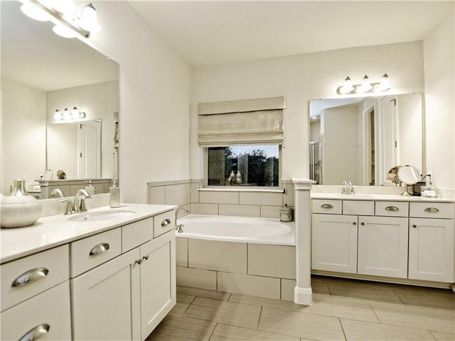 Full bathroom featuring a bath, two vanities, and a stall shower | Image 21