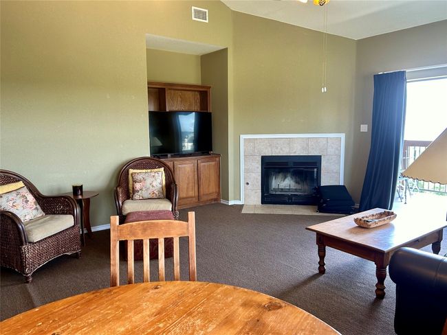 Carpeted living area featuring healthy amount of natural light, a fireplace, and baseboards | Image 8
