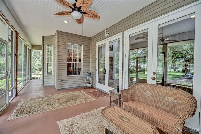 Screened front porch with view through trees of airstrip | Image 30