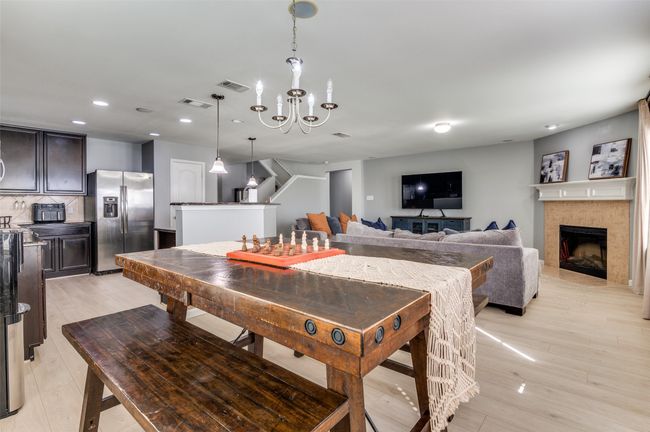Dining area with recessed lighting, a fireplace, light wood-style flooring, and a chandelier. | Image 22
