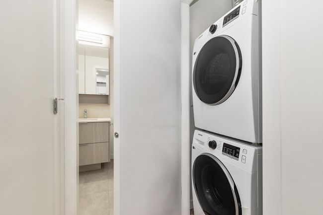 Washroom featuring stacked washer / drying machine and light tile patterned flooring | Image 15