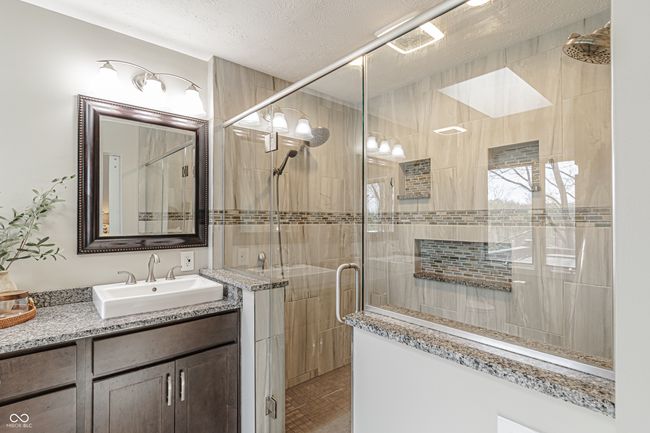 bathroom with vanity, a textured ceiling, and a stall shower | Image 27