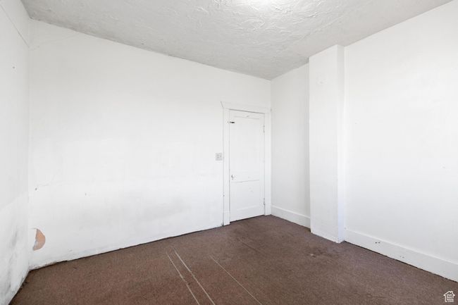 Empty room featuring dark colored carpet and a textured ceiling | Image 12