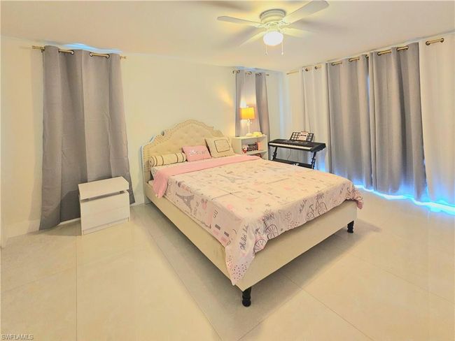 Bedroom with ceiling fan and light tile patterned floors | Image 21