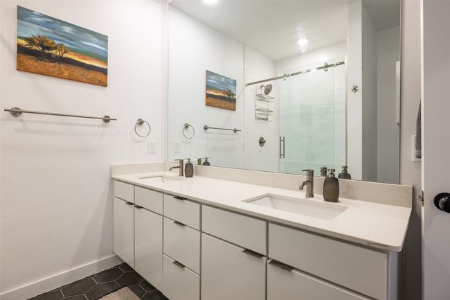 Bathroom featuring a shower stall, tile patterned floors, double vanity, and a sink | Image 22