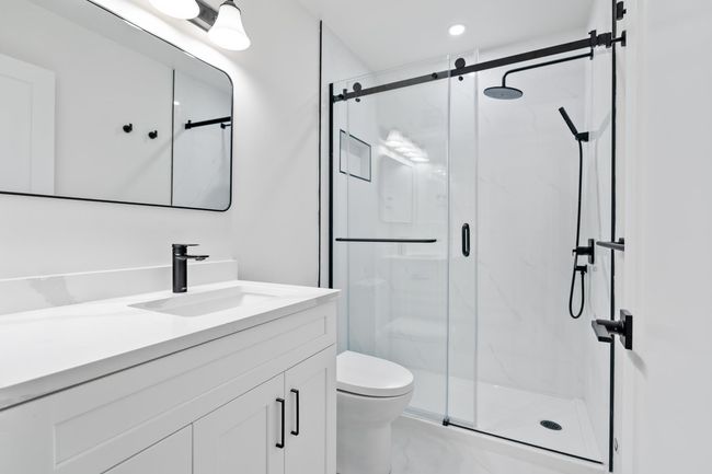 Full bathroom with vanity, toilet, marble finish floor, and a marble finish shower | Image 8