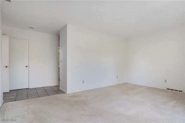 Tiled spare room with baseboards, visible vents, and carpet | Image 30