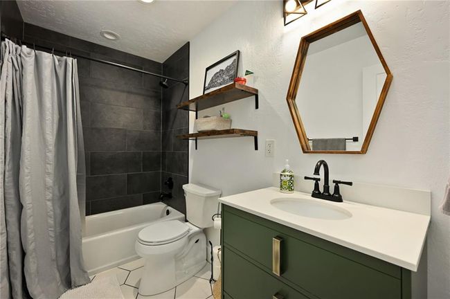 Bathroom with vanity, toilet, shower / bath combo, and tile patterned flooring. Quartz counters. | Image 39