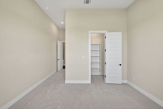 Unfurnished bedroom with light colored carpet, a walk in closet, and recessed lighting | Image 23