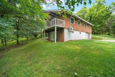 View of side of property featuring a wall mounted AC and a lawn | Image 3