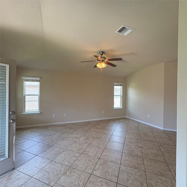 Living room from dining room view with light tile patterned floors and ceiling fan | Image 17