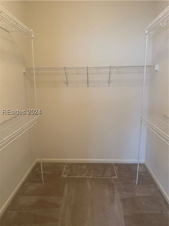 Spacious closet with dark carpet | Image 18