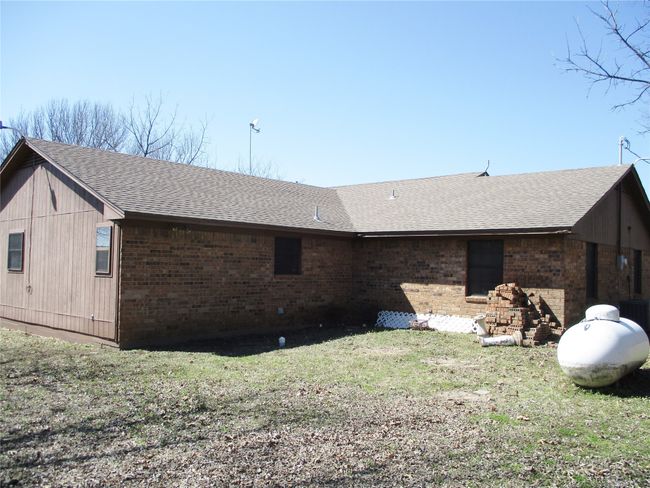 View of side of home featuring brick siding, roof with shingles, and a lawn | Image 22