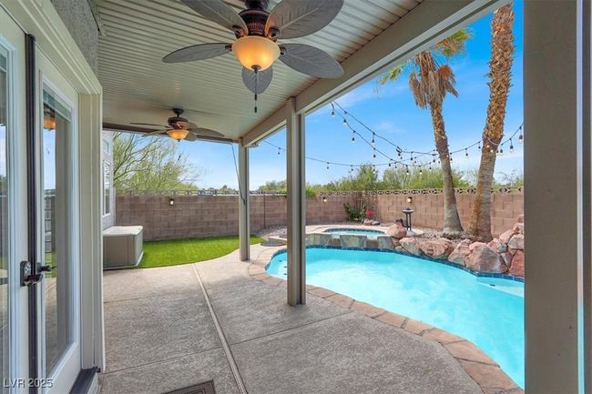 View of pool with a fenced backyard, a ceiling fan, a patio, and a pool with connected hot tub | Image 35