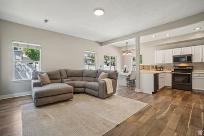 Living room with sink, a notable chandelier, and dark hardwood / wood-style flooring | Image 2