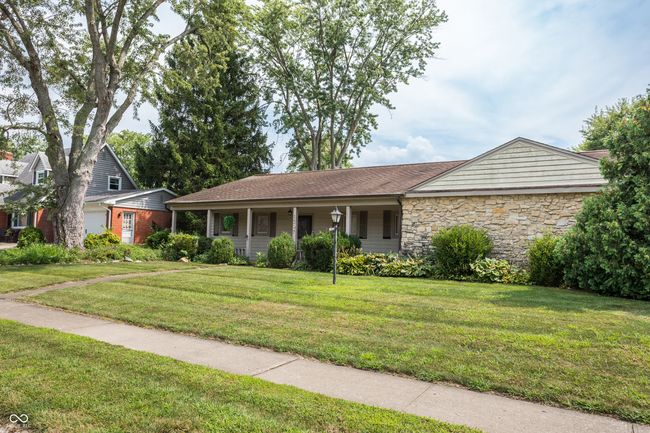 ranch-style home with stone siding, a front lawn, and covered porch | Image 4