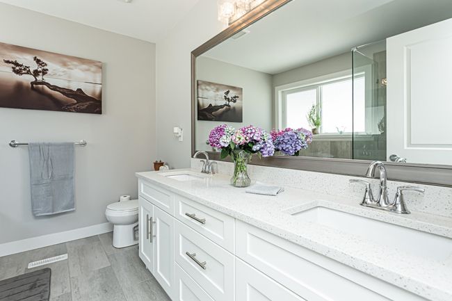 Bathroom featuring toilet, a sink, double vanity, and a stall shower | Image 6
