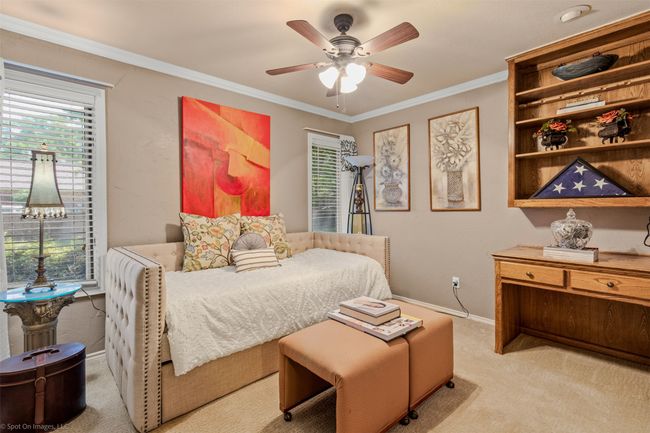 guest Bedroom with crown molding, carpet, ceiling fan, built in desk and large windows | Image 22