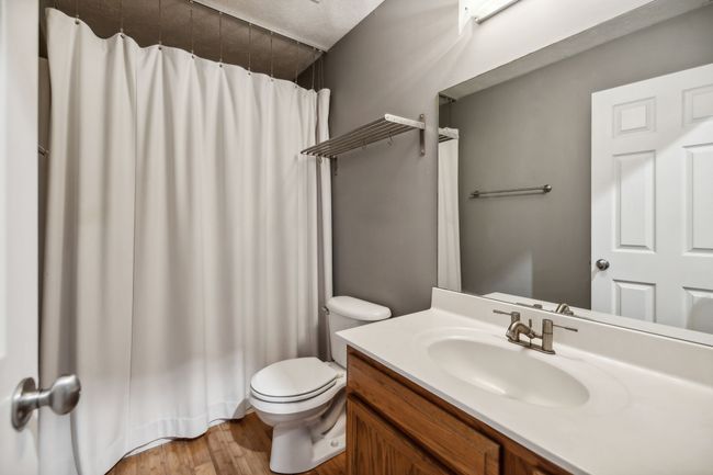 The guest bath features an oversized vanity with sleek stainless shelving and stylish bamboo flooring, all complemented by a lovely, modern paint color that adds a touch of elegance to the space. 2095 Bolden Drive, Murfreesboro, TN 37127 | Image 19