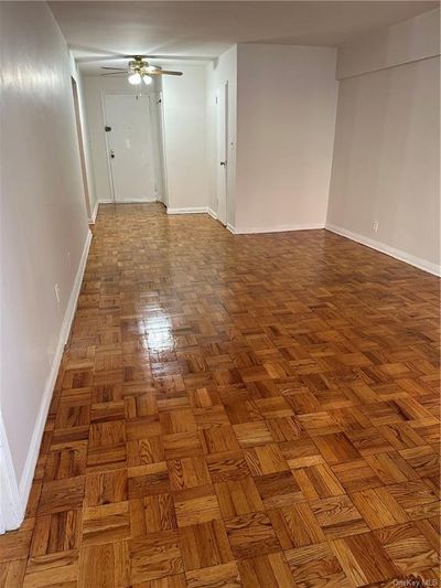 Empty room with ceiling fan and parquet floors | Image 2