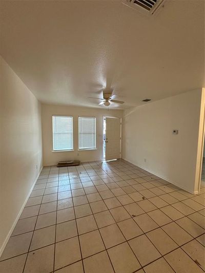 Tiled spare room with ceiling fan | Image 2