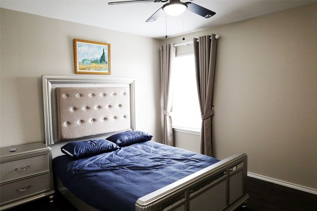 Bedroom with a ceiling fan, baseboards, and multiple windows | Image 13