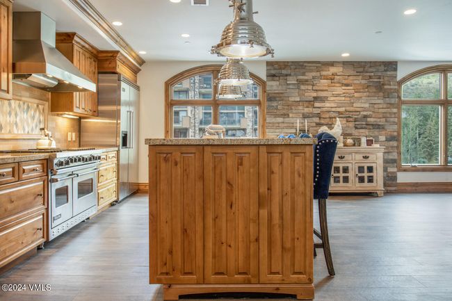 Thoughtfully designed for entertaining, the kitchen flows seamlessly into the open living space. Natural finishes, high-end appliances, and artisan lighting bring function and warmth together beautifully. | Image 6