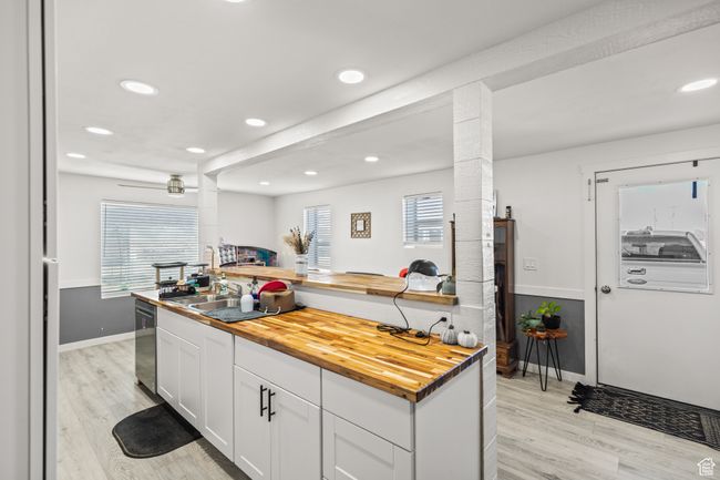Kitchen with butcher block counters, dishwasher, light wood finished floors, and recessed lighting | Image 5