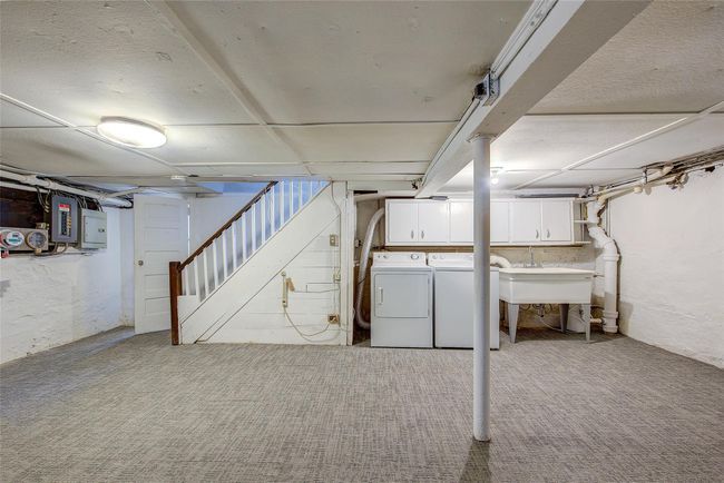 Finished basement featuring washer and dryer, electric panel, stairs, and carpet floors | Image 38
