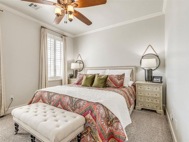 Bedroom featuring light carpet, baseboards, visible vents, and crown molding | Image 27