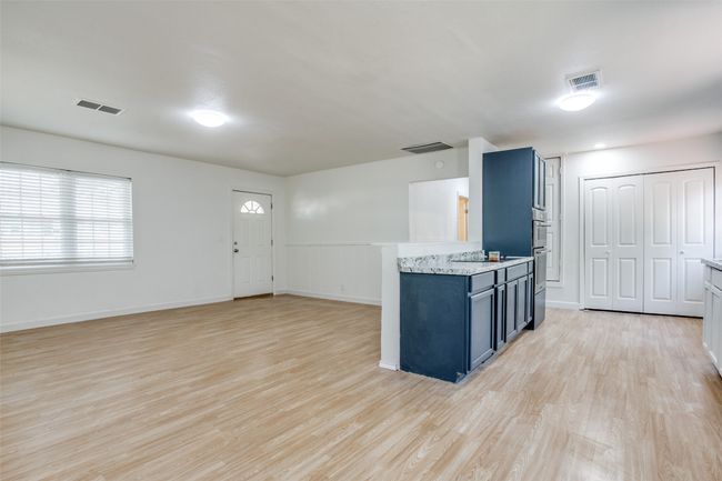 Kitchen with light wood-style floors, blue cabinets, and wainscoting | Image 6