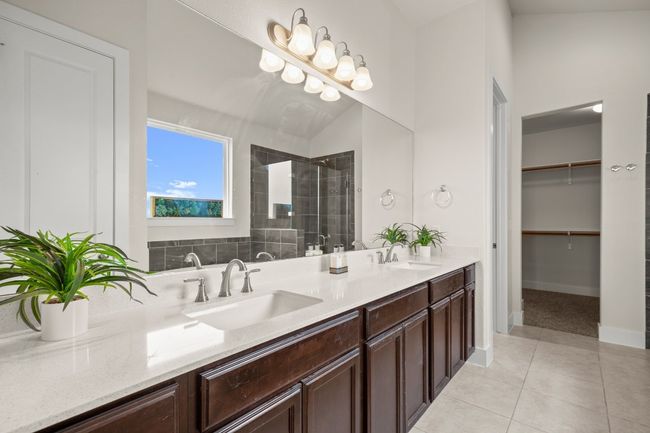 Bathroom with tiled shower, double vanity, tile patterned flooring, and a walk in closet | Image 12