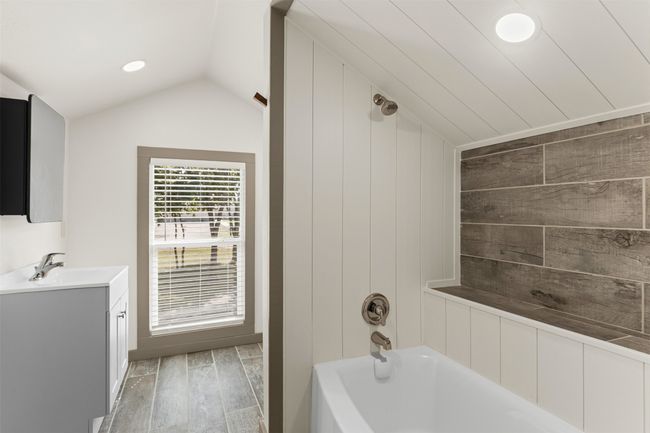 Bathroom with vanity, vaulted ceiling, wood finished floors, shower / bath combination, and recessed lighting | Image 30