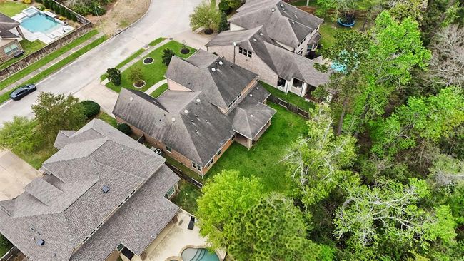 Aerial view showcases the privacy of this spacious backyard with no rear neighbors, backing to a lush greenbelt. Ideal for relaxing or entertaining, this peaceful setting offers the perfect blend of nature and neighborhood living. | Image 38