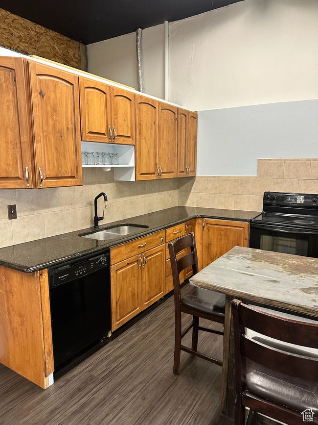 Kitchen with black appliances, decorative backsplash, sink, and dark wood-type flooring | Image 16
