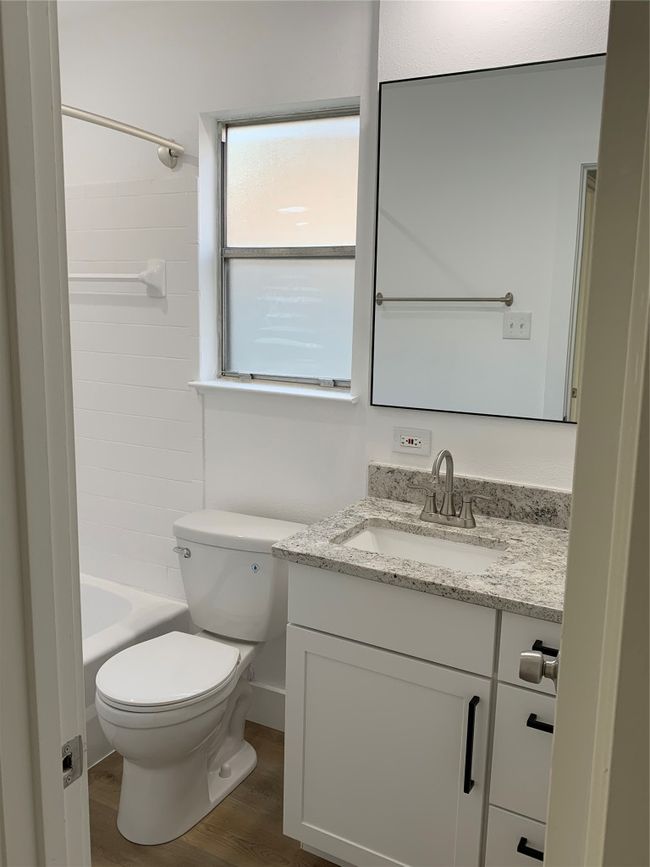 Bathroom with vanity, wood finished floors, and shower / washtub combination | Image 22