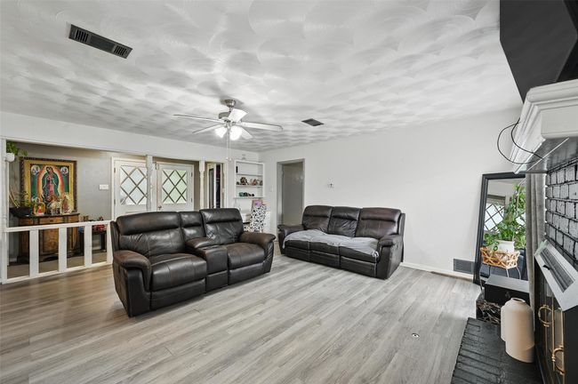 Living room featuring a ceiling fan, wood finished floors, and baseboards | Image 8