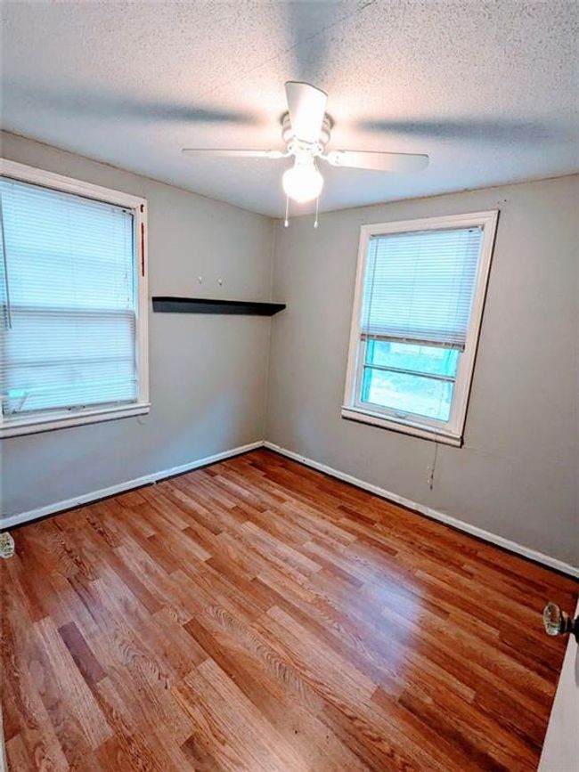 Unfurnished room with wood finished floors, a textured ceiling, and a ceiling fan | Image 13