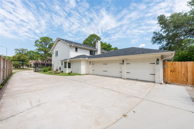 This home features a large driveway, a three-car garage, and an automatic gate. | Image 46