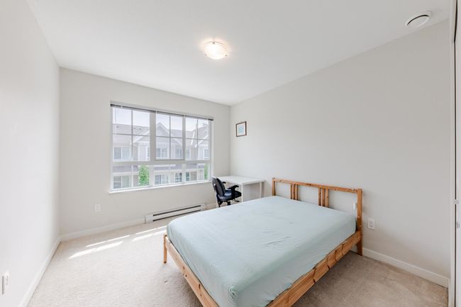 Bedroom featuring baseboard heating and light colored carpet | Image 23
