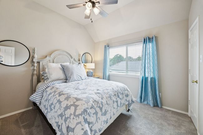 Bedroom with carpet, vaulted ceiling, ceiling fan and walk-in closet | Image 27