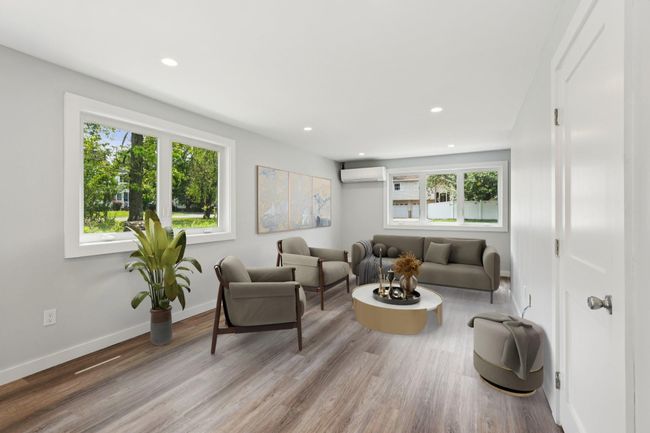 Living room featuring a wall unit AC, recessed lighting, and wood finished floors Virtually Staged | Image 7