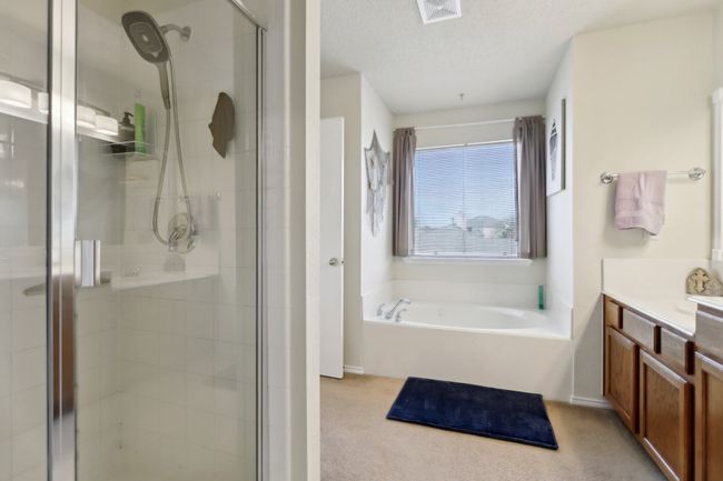 Full bathroom with vanity, a garden tub, a shower stall, a textured ceiling, and visible vents | Image 22