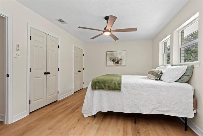 Master bedroom with new windows, fresh paint, luxury vinyl plank flooring, and double closets | Image 12